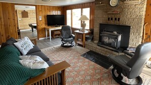 Una sala de estar acogedora con chimenea, televisor y asientos cómodos.