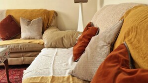 Ein gemütliches Wohnzimmer mit einer Couch, einem Couchtisch und einer Lampe.