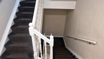 A staircase with white balusters and a handrail, leading to an upper floor.