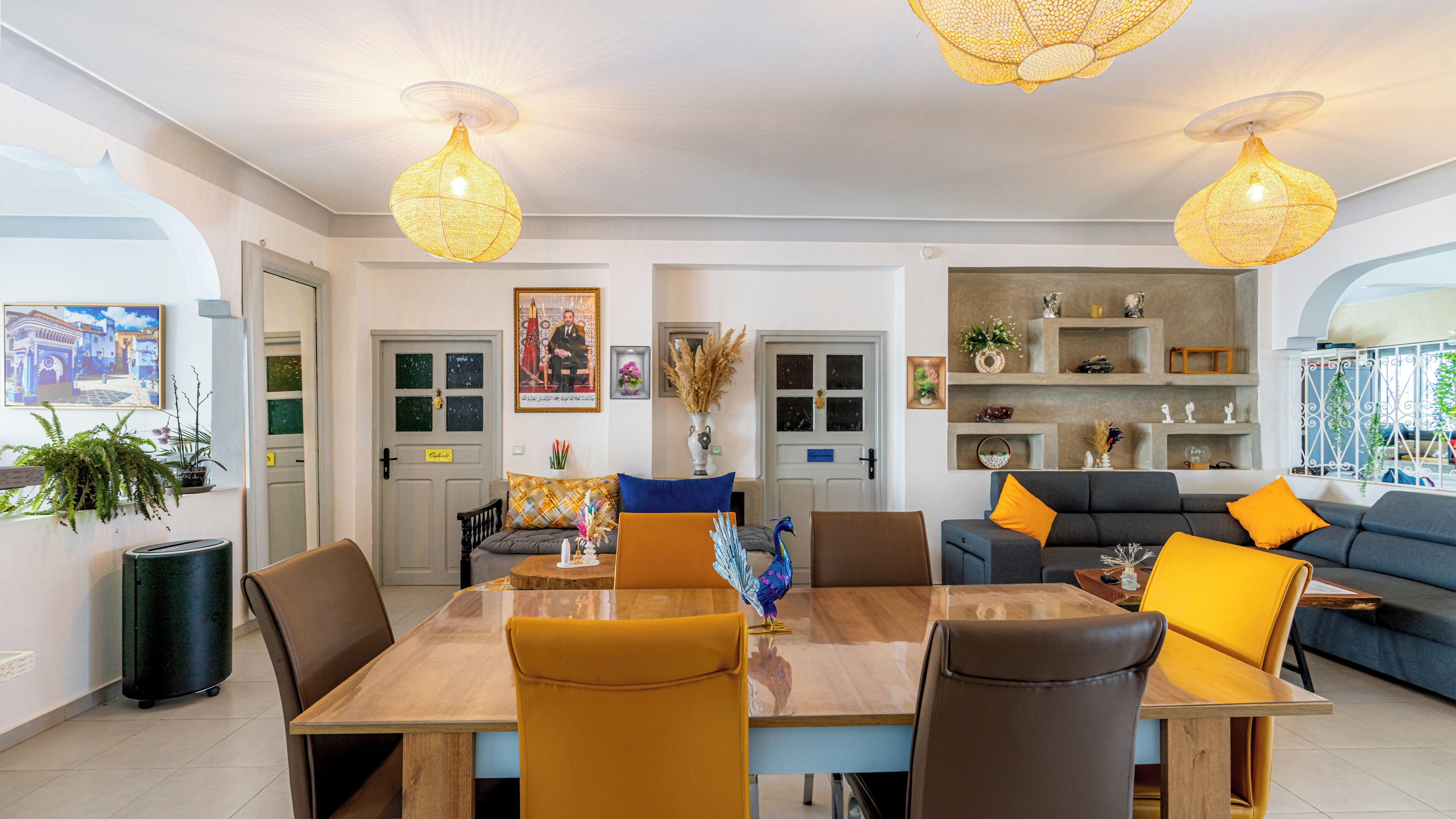 Una sala de estar moderna con comedor, que incluye un sofá, sillas, una mesa de madera y objetos decorativos.