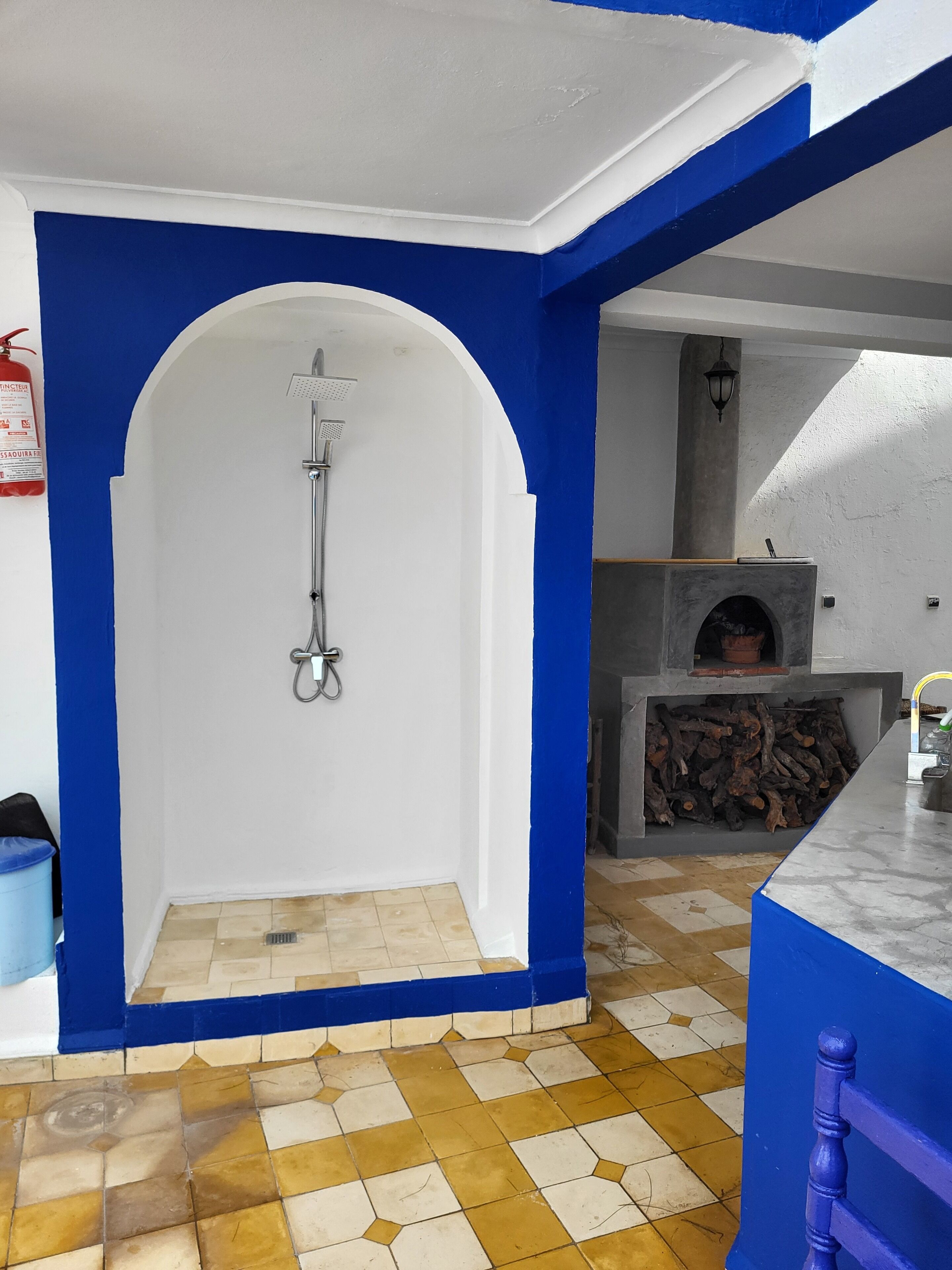 A bathroom with a shower, a blue and white color scheme, and a tiled floor.