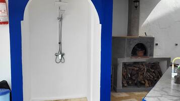 A bathroom with a shower, a blue and white color scheme, and a tiled floor.