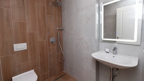 Un baño moderno con ducha, inodoro y lavamanos.