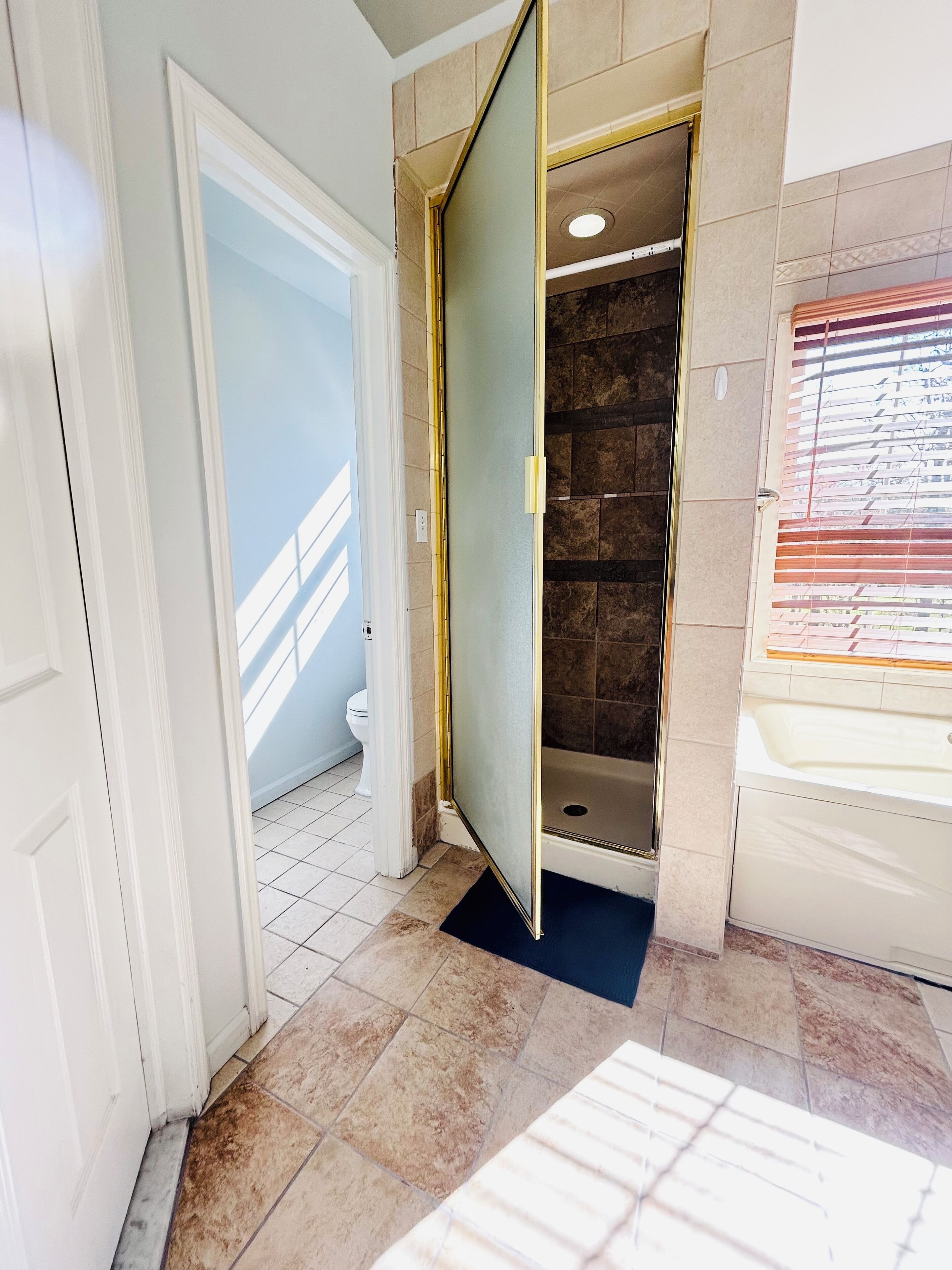 Een badkamer met een douche, toilet en bad.