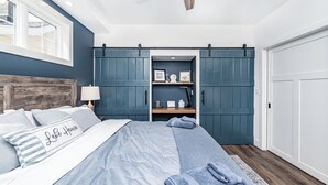 Une chambre à coucher avec un lit, un ventilateur de plafond, une armoire et une fenêtre.