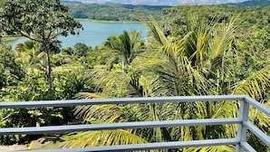 A lush landscape with a view of a lake and distant hills. - The Fruit Tree Garden Bromeliad Suite (Arenal)