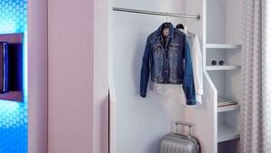 A room with a white wardrobe, a hanging rack with clothes, and a suitcase. - B&B Hotel Bremen-altstadt (Bremen)