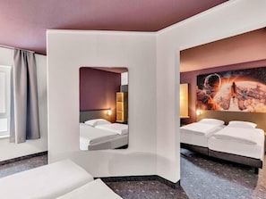 A hotel room with a bed, a seating area, and a large painting of a space scene. - B&B Hotel Bremen-altstadt (Bremen)
