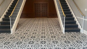 A grand staircase with a patterned floor leading to a wooden door. - Cozy Stylish Executive Studio, Great Downtown Pascagoula Location (Pascagoula)