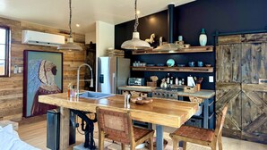 Une cuisine moderne avec des meubles en bois, un îlot central et des luminaires suspendus.