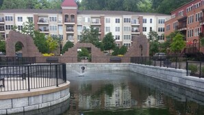 A courtyard with a central water feature, surrounded by brick buildings with multiple windows and balconies.