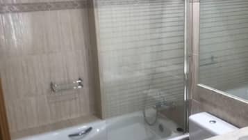 Een douche, handdoeken, zeep, toiletpapier
