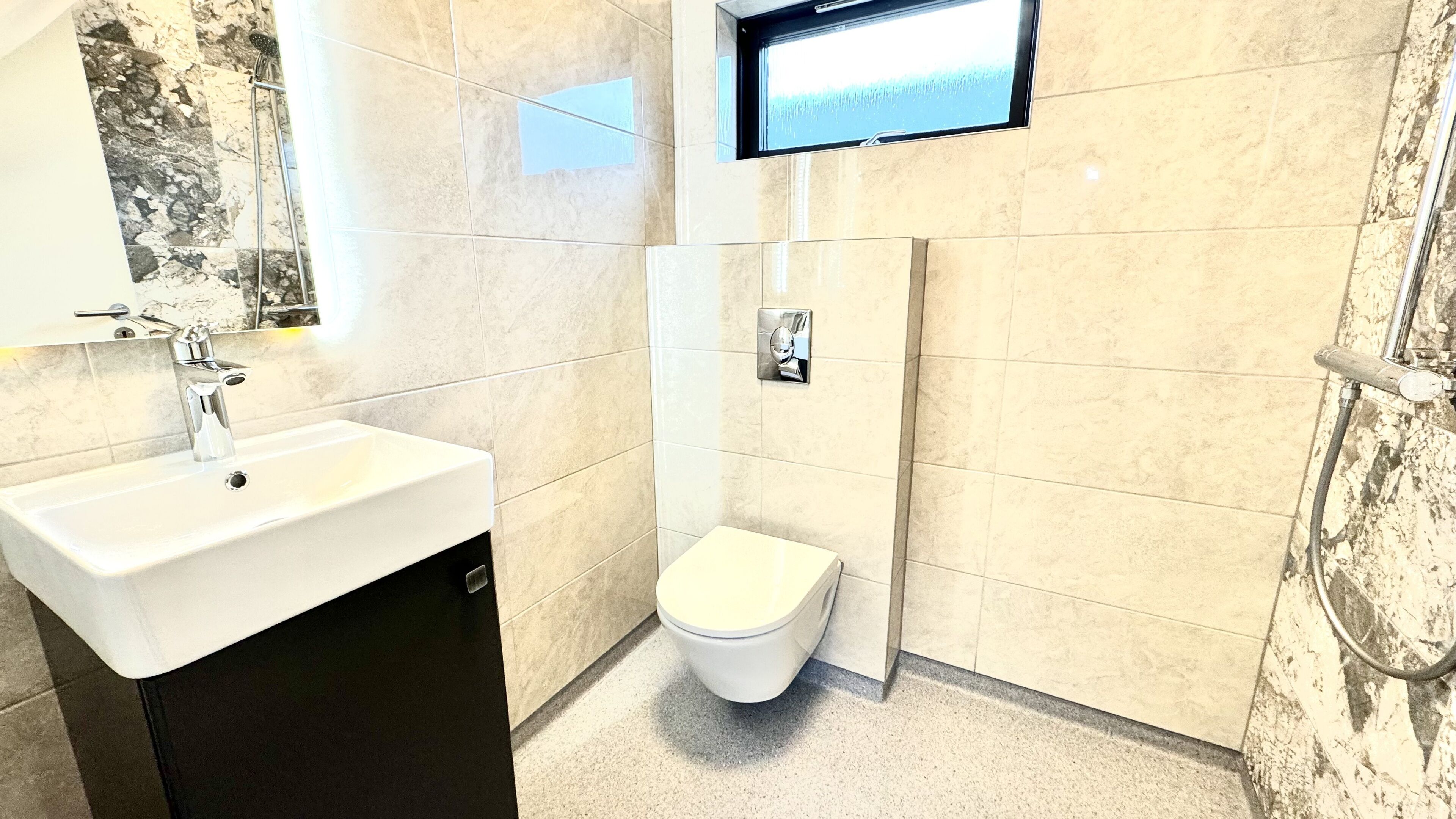 A bathroom with a white sink, a toilet, and a shower.