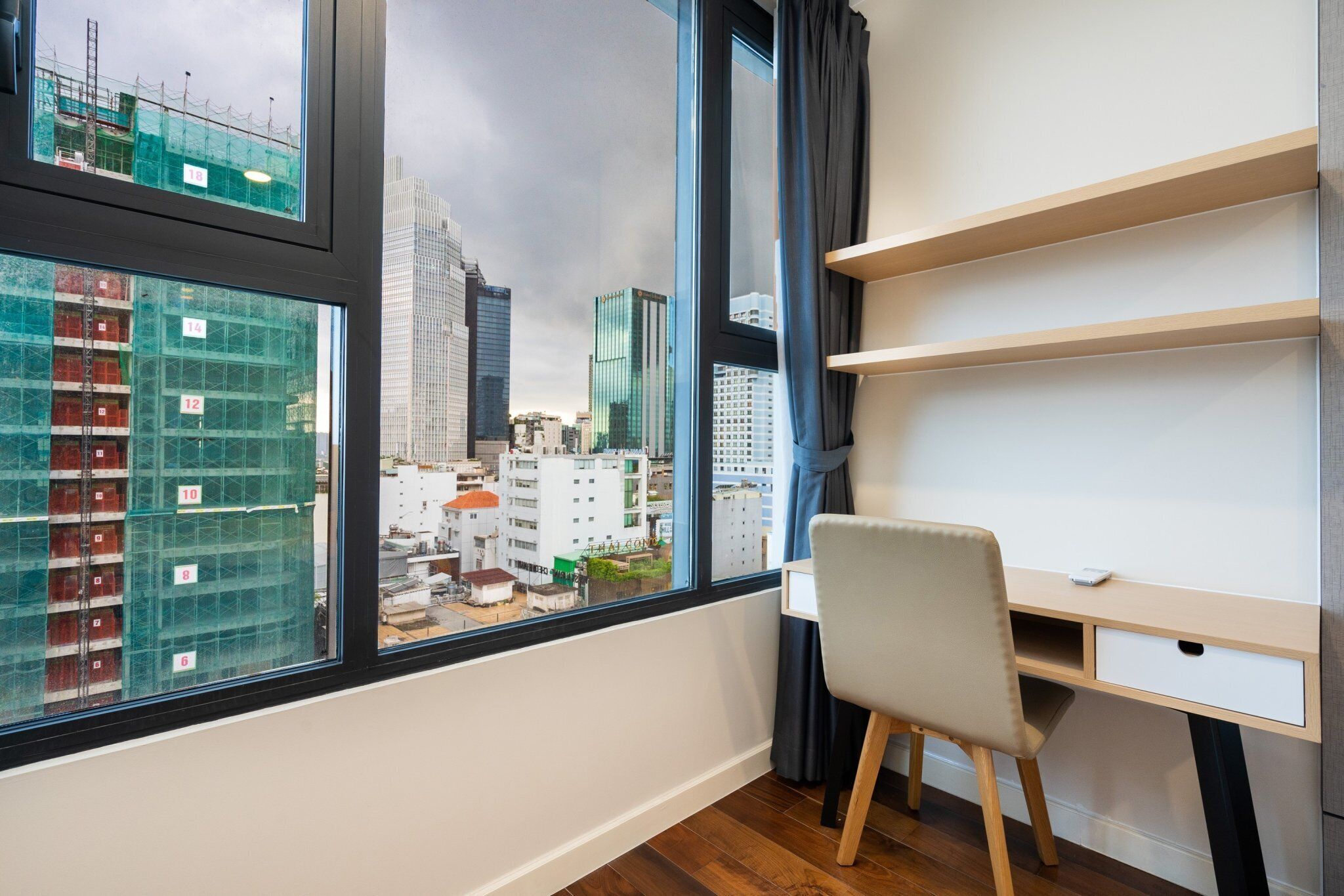 Una habitación moderna con un ventanal grande, un escritorio y una silla.