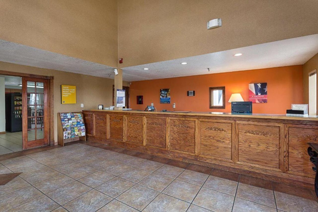 A reception area with a wooden counter, a bulletin board, and a sign on the wall.