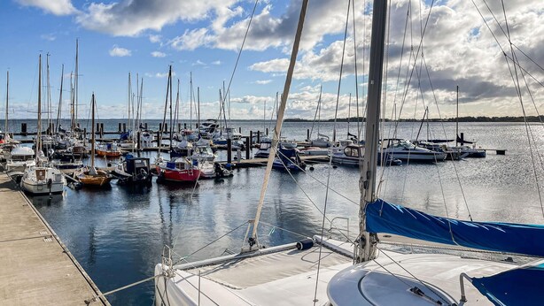 Ein Yachthafen mit mehreren Segelbooten an der Pier.