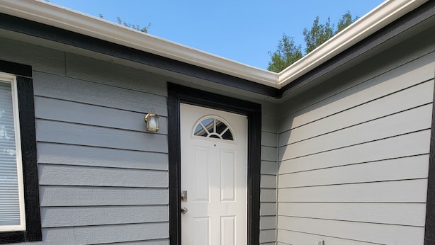 A house with a white front door, a small porch, and a garage. - Charming, Cozy Boise Duplex (Boise)