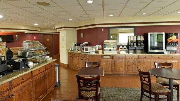 A breakfast area with a buffet, seating, and kitchen appliances.