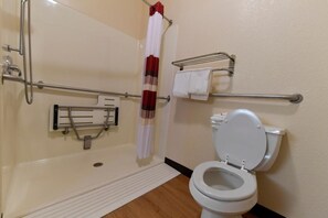 A bathroom with a shower, toilet, grab bars, and a towel rack. - Baymont Inn & Suites by Wyndham Lincoln NE (Lincoln)