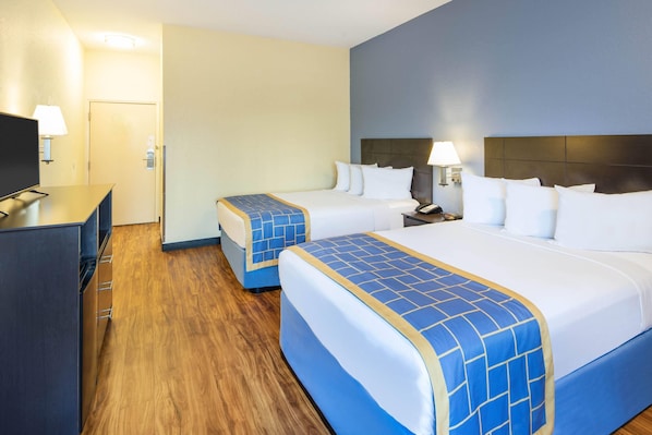 A hotel room with two beds, a desk, and a television. - Days Inn by Wyndham Macon I-75 North (Macon)