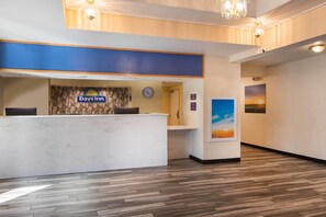 Uma receção com o letreiro Days Inn, um relógio e uma pintura de um pôr do sol.