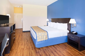 A hotel room with a bed, bedside lamps, a TV, and a desk. - Days Inn by Wyndham Macon I-75 North (Macon)