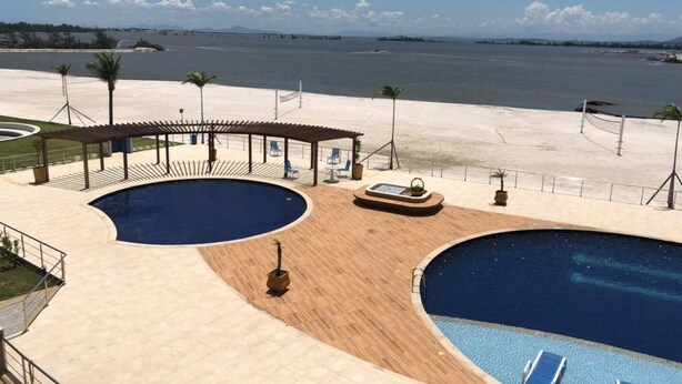 Ein Poolbereich mit zwei großen Pools, Liegestühlen und einer überdachten Lounge im Golden Lake Residence Apart Hotel.