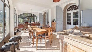 A spacious dining area with a large table and chairs, a piano, and a decorative elephant statue. - Centre Ville à Pied Dans une Authentique Bastide Xviieme Rénovée (Aix en Provence)