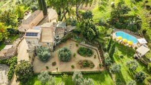 Vista aerea di una proprietà con piscina, edifici in pietra e giardino curato.