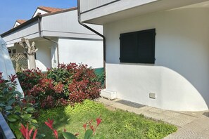 A white building with a window and a white radiator.