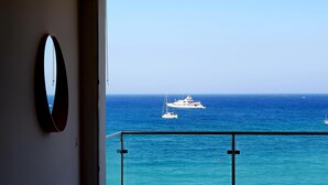 Een balkon met uitzicht op zee en boten.