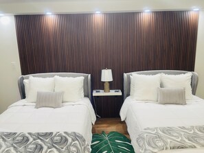 A hotel room with two beds, a nightstand with a lamp, and a wooden panel wall. - Parking Included Upgraded w King Bed Marine Surf Waikiki (Honolulu)