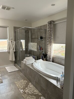A modern bathroom with a glass-enclosed shower, a large bathtub, and a vanity with toiletries. - Lake Las Vegas Community 
Ultimate Retreat with beautiful views private & gated  (Las Vegas)