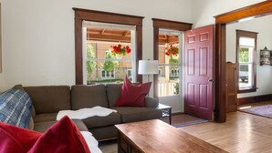 A living room with a sofa, a wooden coffee table, and a door leading outside. - Cozy and charming. Your home away from home in the heart of Viroqua. (Viroqua)