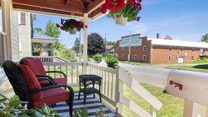 A porch with wicker chairs and a mailbox. - Cozy and charming. Your home away from home in the heart of Viroqua. (Viroqua)