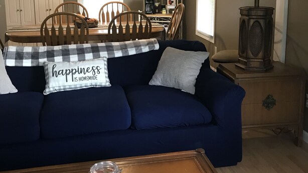 A living room with a dark blue sofa, a coffee station, wooden chairs, and a lamp. - Quiet, 3 bedroom & 1 bath get-a-way. Near Lake Erie for fishing & skiing resorts (Albion)