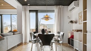 A modern dining area with a round table, black chairs, and a pendant light. - Awesome home in Haderslev with WiFi (Haderslev)