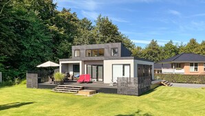A modern two-story house with a patio, a barbecue area, and a small deck. - Awesome home in Haderslev with WiFi (Haderslev)