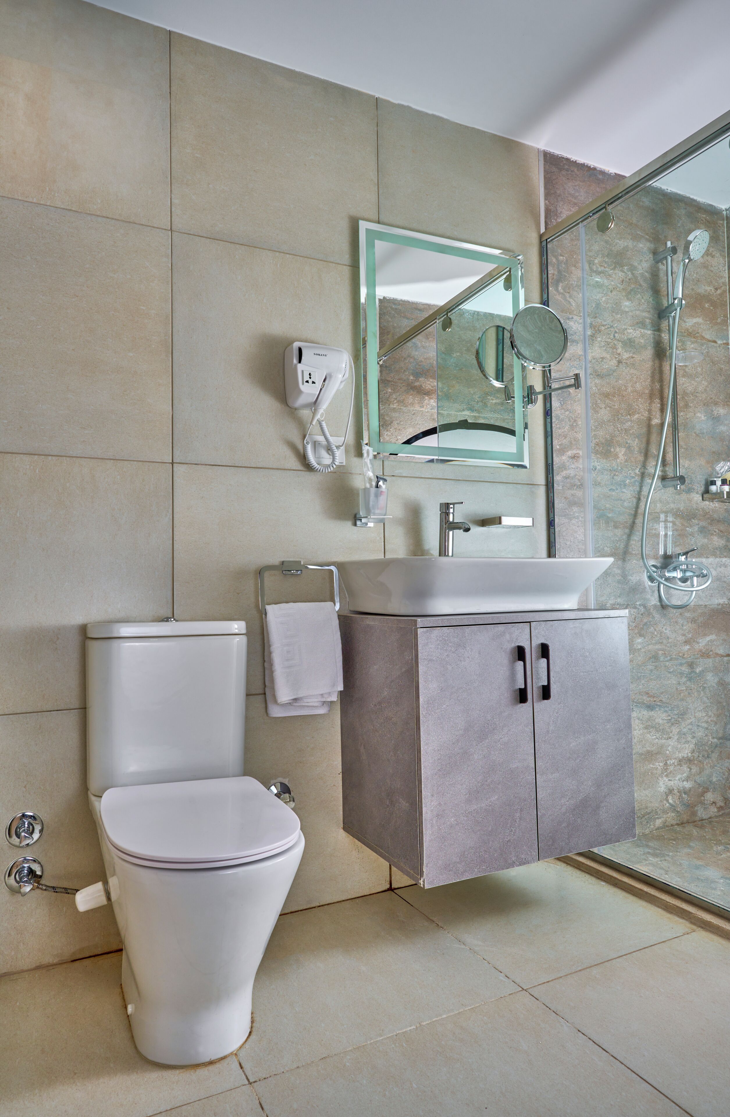 A modern bathroom with a toilet, sink, and shower.