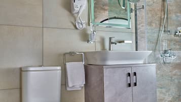 A modern bathroom with a toilet, sink, and shower.