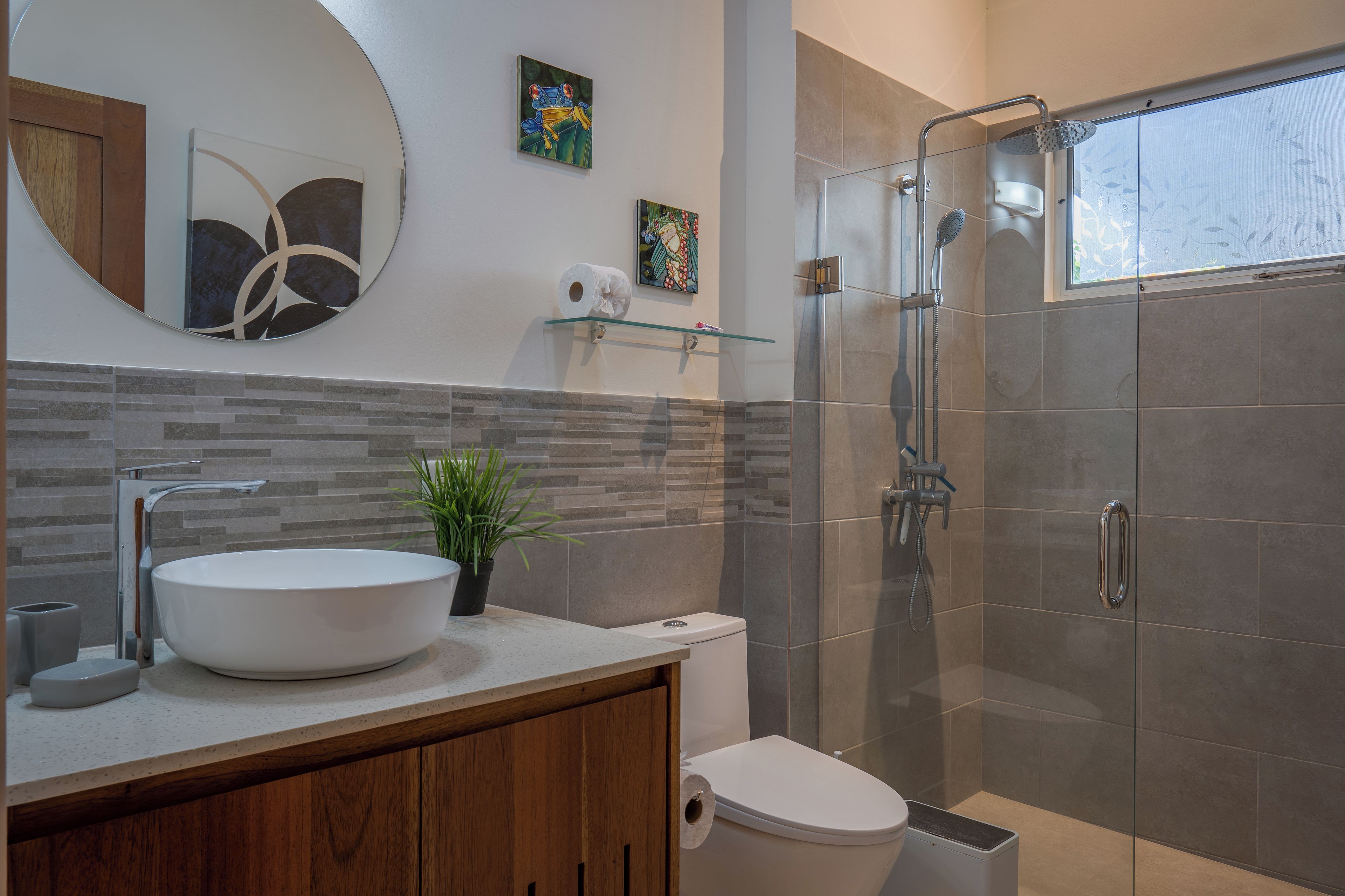 A modern bathroom with a large sink, toilet, and shower.