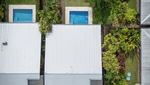 Propiedad residencial con dos piscinas, un patio cubierto y un jardín bien cuidado.