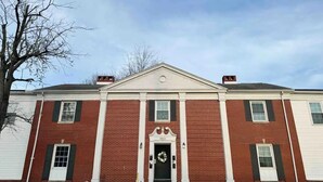 A red brick building with a central entrance, white trim, and a number "960" above the door. - Spring Street Suites A / Stylish 3BD/1BA Apt (Evansville)