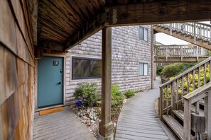 A wooden exterior with a door marked '3', a wooden deck, and a staircase leading to a balcony.