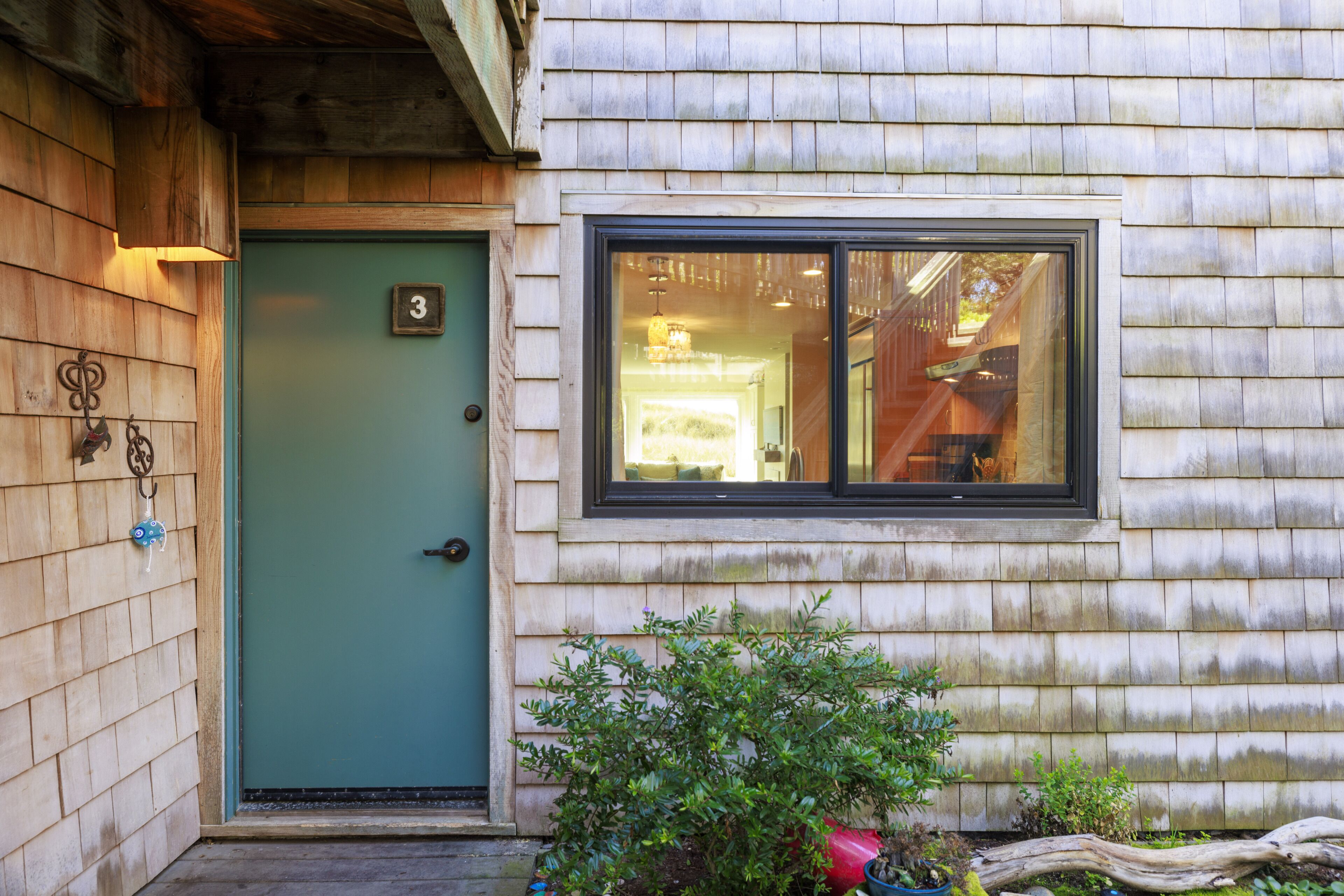A wooden house with a green door and a window.