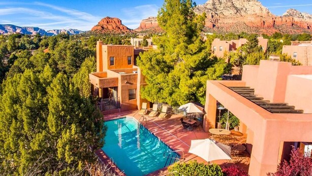 Un resort con piscina, mobiliario exterior y vistas a las montañas.
