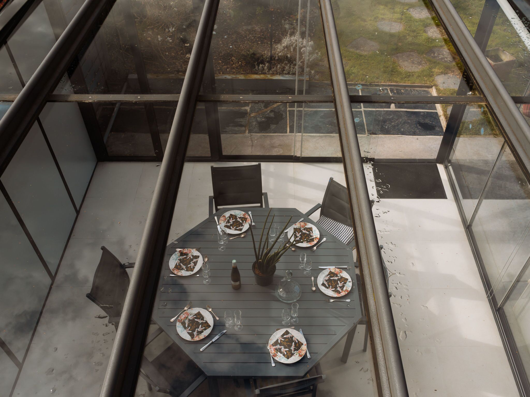 A dining area with a table set for four, surrounded by chairs.