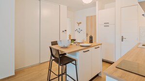 Una cocina moderna con encimera de madera, un tazón blanco y una silla negra.