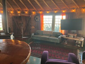 Ein rustikales Interieur mit einer Couch, einem Fernseher und einem Couchtisch.