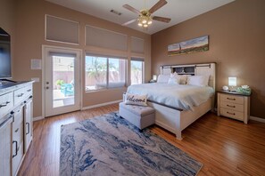 A bedroom with a bed, a nightstand, a television, a ceiling fan, and a view of the outdoors through a door. - Rare 3 FULL bathroom home in golf community W/ private pool. Experienced Host. (Mesa)